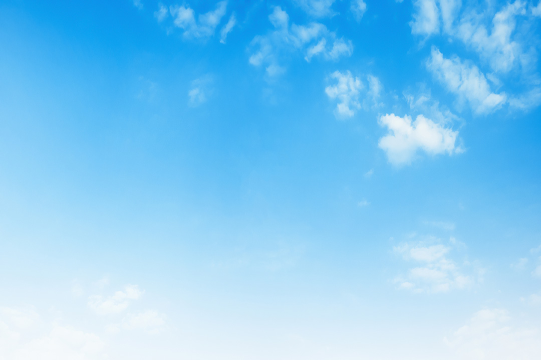 The image displays a clear blue sky with a few wispy clouds, viewed from below, looking up towards the horizon.