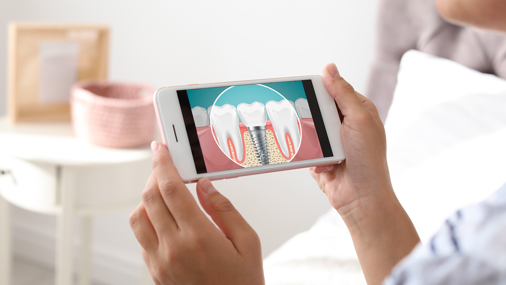 The image shows a person holding a smartphone displaying an animated tooth with a cavity, set against a blurred background that includes a person s hand and part of a white wall.