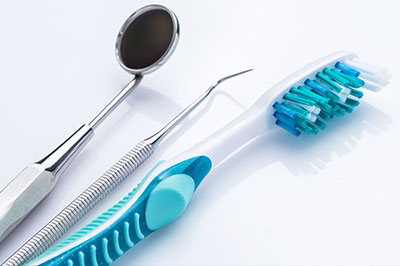 Dental tools and a toothbrush set against a white background.