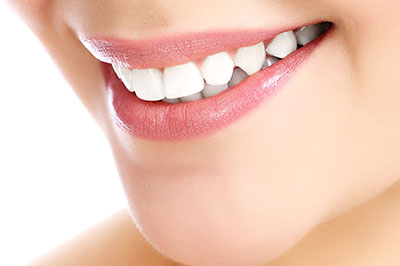 The image features a close-up of a person s face with a focus on their teeth, showcasing the results of dental treatment or cosmetic enhancement.