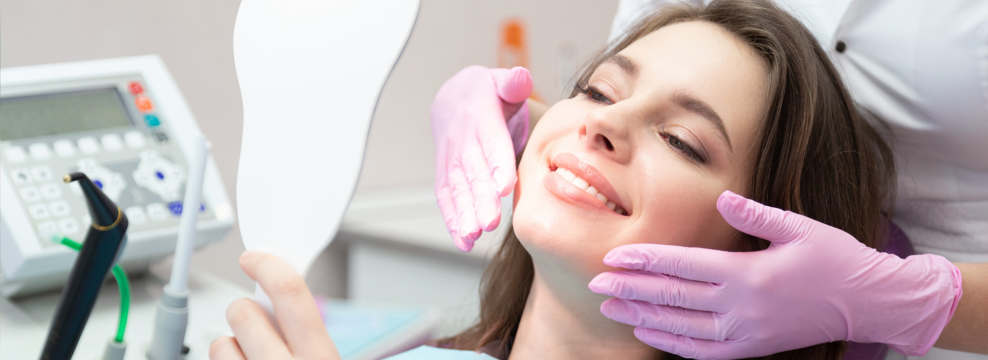 A woman receiving dental care, with a dentist performing an examination and cleaning her teeth.