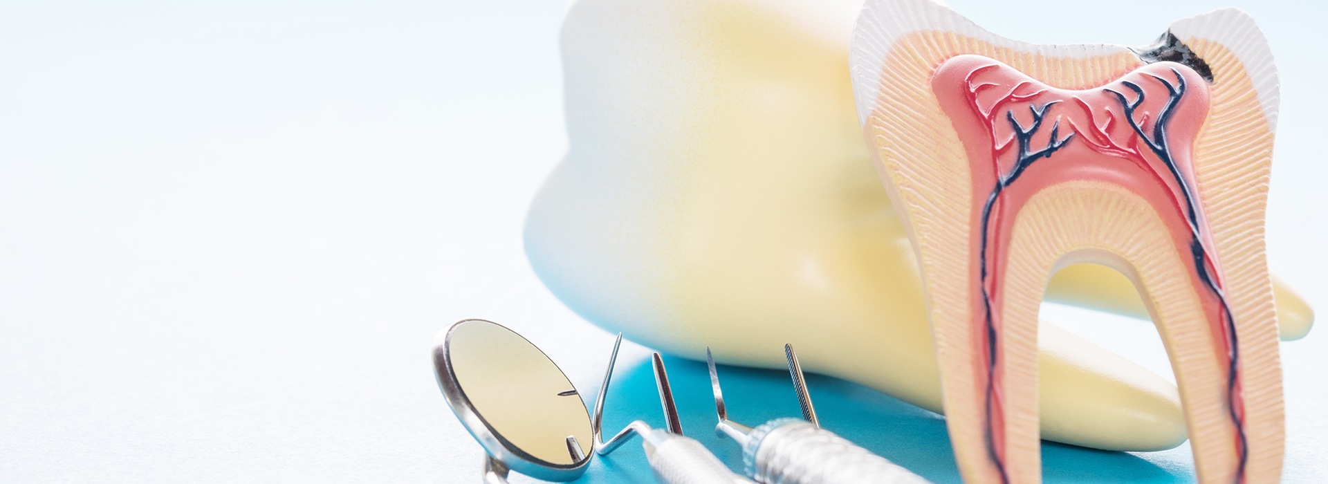 The image shows a close-up of dental tools, including a pair of tweezers and a dental mirror, with a focus on the mouth area, possibly for educational or promotional purposes.