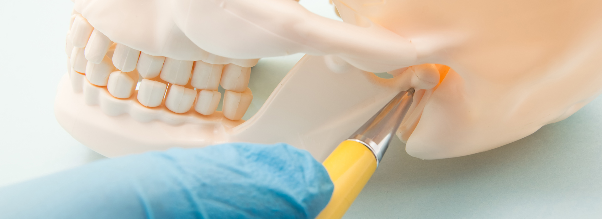 An image depicting a dental procedure with a focus on a tooth being prepared for implantation, featuring a close-up of a surgical instrument and a dental model.